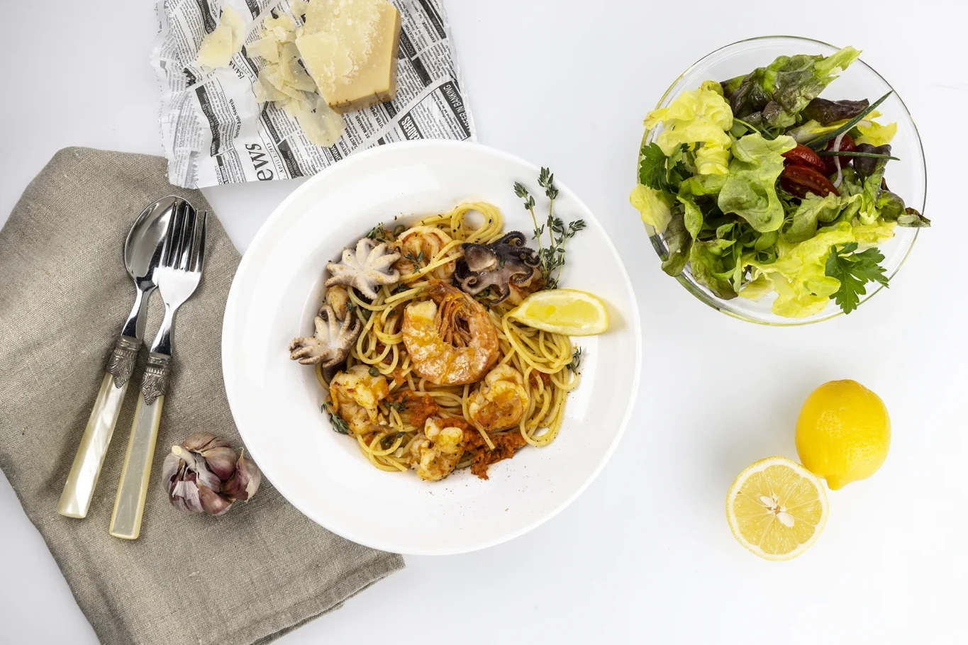 Pasta mit Meeresfrüchten, Zitrone, frischem Salat und auf einem Tisch serviert.
